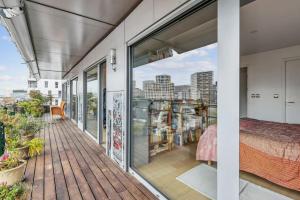 a room with a balcony with a bed and a view at Magnifique appartement sur parc in Paris