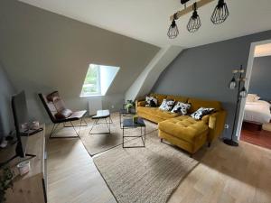a living room with a yellow couch and chairs at Appartements Cherbourg in Cherbourg en Cotentin