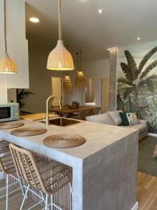 a kitchen with a bar with chairs and a living room at Paraíso Rias Baixas in Pontevedra