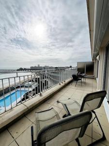 einen Balkon mit Stühlen und Blick auf das Wasser in der Unterkunft Mirasables - Appartement dernier étage terrasse vue mer in Les Sables-dʼOlonne