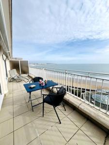 einen Balkon mit einem blauen Tisch, Stühlen und Meerblick in der Unterkunft Mirasables - Appartement dernier étage terrasse vue mer in Les Sables-dʼOlonne