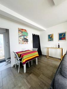 ein Wohnzimmer mit einem Tisch und einem Sofa in der Unterkunft Mirasables - Appartement dernier étage terrasse vue mer in Les Sables-dʼOlonne