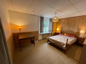 Schlafzimmer mit einem Bett, einem Tisch und einem Fenster in der Unterkunft Appartement à Uriage les Bains. in Vaulnaveys-le-Haut