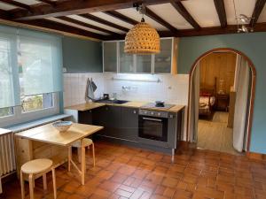 eine Küche mit einem Tisch und einem Tisch sowie ein Esszimmer in der Unterkunft Appartement à Uriage les Bains. in Vaulnaveys-le-Haut