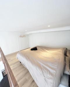 een bed in een kamer met een witte muur bij Mayfair Suites in Antwerpen