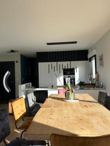 une cuisine et une salle à manger avec une table en bois dans l'établissement Perle des Abers Plage de Béniguet, à Saint-Pabu