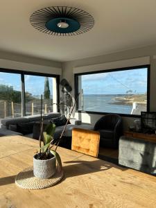 - un salon avec une table et une vue sur l'océan dans l'établissement Perle des Abers Plage de Béniguet, à Saint-Pabu 5 autres photos