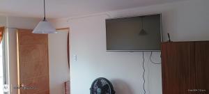 Habitación con ventilador y TV en la pared. en Se arrienda departamento en caldera, en Caldera