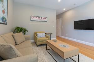 sala de estar con sofá y mesa de centro en Sunny convenient home w/ private patio! Easy walk to everything! en Boston