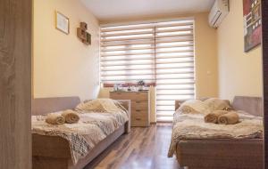 twee bedden in een kamer met een raam bij Apartmani Bašta in Višegrad