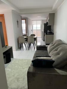 ein Wohnzimmer mit einem Sofa und einem Esszimmer in der Unterkunft Apartamento novo no centro de Guarapuava - PR in Guarapuava