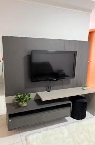 a flat screen tv hanging on a wall at Apartamento novo no centro de Guarapuava - PR in Guarapuava