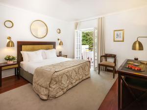 a hotel room with a large bed and a table at Casa Senhoras Rainhas - Óbidos - by Unlock Hotels in Óbidos