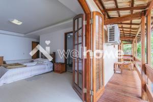 um quarto numa villa com uma cama e uma varanda em Casa com piscina e churrasqueira em Teresópolis em Teresópolis