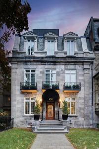 a large stone house with a front door and stairs at Hotel St-Thomas in Montréal