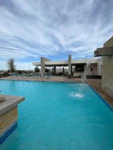 a large blue pool with a fountain in front of a building at Casa vacacional Mar&Paz in La Paz