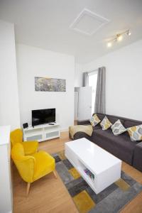 a living room with a black couch and a yellow chair at Great 2 Bedroom Apartment 6 Shirley Area SO15 Sleeps 6 in Southampton