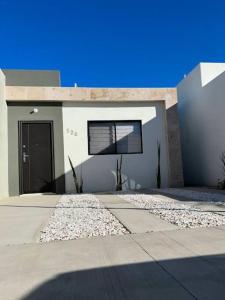 a white house with a door and a driveway at Casa vacacional Mar&Paz in La Paz