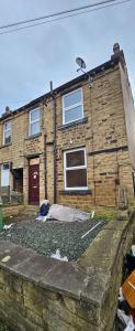 a brick house with a mattress in front of it at The Luxe - Entire House in Huddersfield