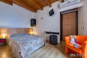sypialnia z łóżkiem i pomarańczową kanapą w obiekcie Locanda Al Moro Hotel w mieście Sciacca