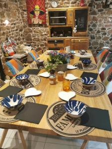 Una mesa de madera con platos azules y blancos encima. en LA FEE VIVIANE, en Villerest