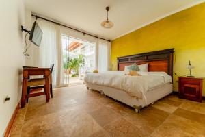 Schlafzimmer mit einem Bett, einem Schreibtisch und einem Stuhl in der Unterkunft Hotel Boutique Noelani in Zorritos