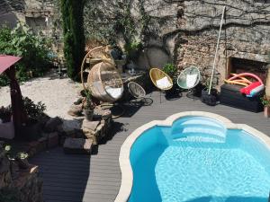 een zwembad op een houten terras met een zwembad bij LA FEE VIVIANE in Villerest