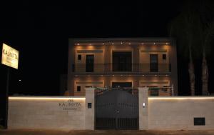 uma casa com uma cerca em frente à noite em Kalinifta Residence em Carpignano Salentino