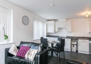 a kitchen and a living room with a table and chairs at Levon House 2 Bed Apt with Netflix & Parking in Coventry in Longford