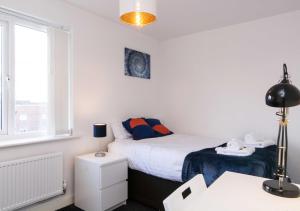 a bedroom with a bed and a desk and a window at Levon House 2 Bed Apt with Netflix & Parking in Coventry in Longford
