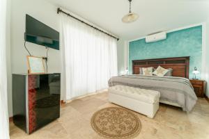 een slaapkamer met een groot bed en een televisie bij Hotel Boutique Noelani in Zorritos