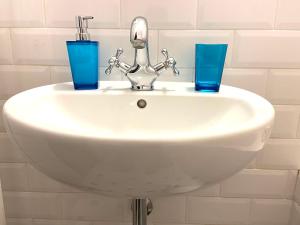 a white sink with two blue glasses on it at Feel like at home in Warsaw