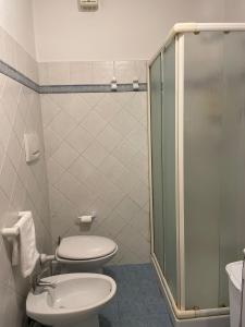 W łazience znajduje się toaleta i przeszklony prysznic. w obiekcie Casa Bianca Stella w mieście Numana