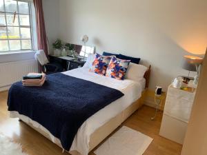 um quarto com uma cama com um cobertor azul em Big bright room em Carrigaline