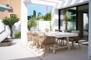 comedor con mesa blanca y sillas en Modern 4 Beds Luxe Villa 550m to Las Cañas Beach!, en Marbella
