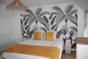 - une chambre avec un lit orné d'une fresque murale de palmiers dans l'établissement Le Cœur du Bien-être - Gîte grande capacité - Superbe emplacement - Vue Seine - Décoration soignée - Coin touristique, aux Andelys