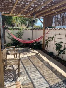 a patio with a hammock and a table and a bench at Cabanon d’Amata in Saint-Raphaël