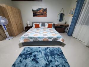 een slaapkamer met een bed en een blauw tapijt bij Big Studio Deluxe King Bed & Sofa Bed with Balcony, Swimming Pool & Gym in Puerto Princesa City