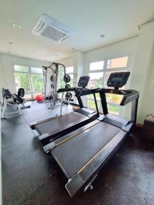 a gym with a treadmill and two tread machines at Big Studio Deluxe King Bed & Sofa Bed with Balcony, Swimming Pool & Gym in Puerto Princesa City