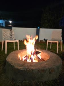 a fire pit in a yard at night with two chairs at Hestia Chalet 3BHK Villa in Ooty