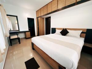 a bedroom with a large bed and a desk at Hestia Chalet 3BHK Villa in Ooty