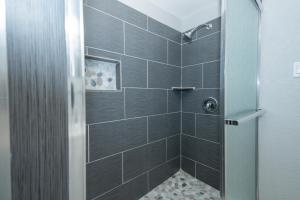 a bathroom with a shower with black tiles at Cultural Heritage Award winning home - Ideal for Holiday Stays & Lake Walks in Austin +30 photos