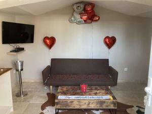 a living room with a couch and two red heart balloons at La nuit glamour in Herblay