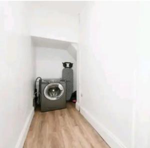 een kamer met een wasmachine in de hoek van een kamer bij Spacious and homely House in Nottingham