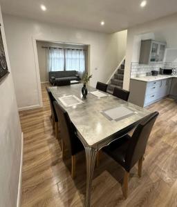 a dining table and chairs in a living room at Spacious and homely House in Nottingham
