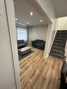 ein Wohnzimmer mit einem Sofa und einer Treppe in der Unterkunft Spacious and homely House in Nottingham