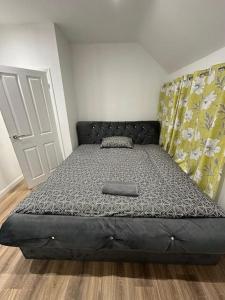 a large bed in a room with a bed frame at Spacious and homely House in Nottingham
