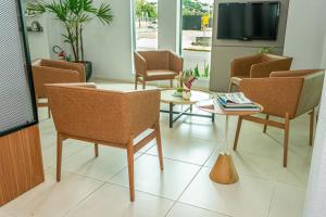 ein Wartezimmer mit Stühlen, einem Tisch und einem TV in der Unterkunft Hotel Guest in Venâncio Aires