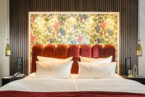a bedroom with a large bed with a large headboard at Hotel Heiligenstein in Baden-Baden