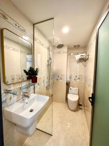 uma casa de banho com um lavatório, um WC e um chuveiro em Victoria Hotel em Ho Chi Minh